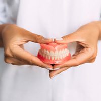 Lady presents viewer with dentures