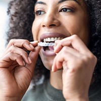 Woman smiling while putting on clear aligner