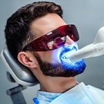 Man having teeth professionally whitened at dental office