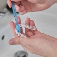 Patient cleaning clear aligner with toothbrush