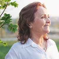 woman smiling after getting dentures