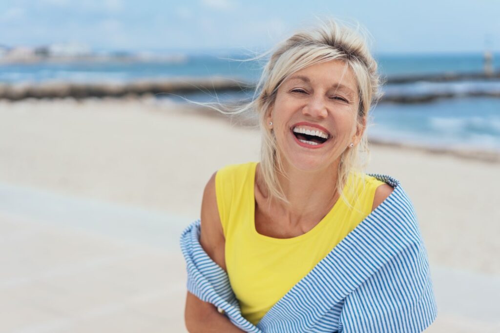 A woman smiling on the beach.
