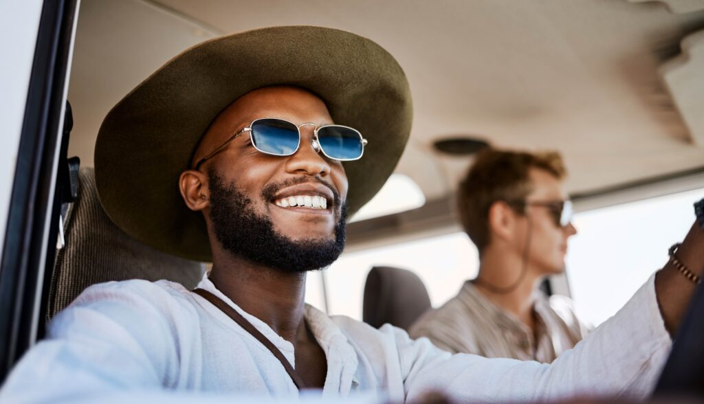 Closeup of man in white shirt smiling on road trip