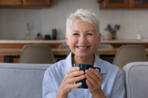 Senior woman smiling while enjoying a cup of coffee