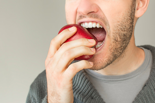 closeup of person eating an apple